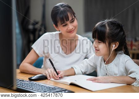 Homeschool Asian Little Young Girl Learning Online Class From School Teacher By Digital Remote Inter