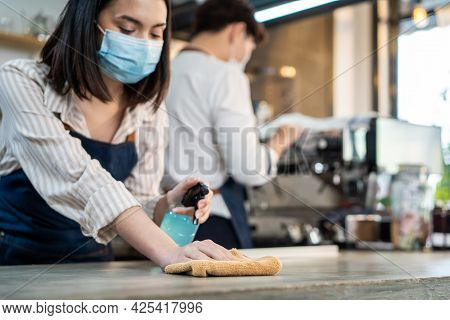 Cafe Waiter Wear Mask, Clean Restaurant With Sanitizer To Open Store. Asian Attrctive Young Couple D