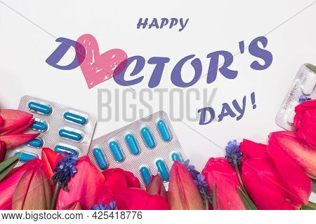 Flowers And Pills With Inscription Happy Doctors Day On White. Greeting Card