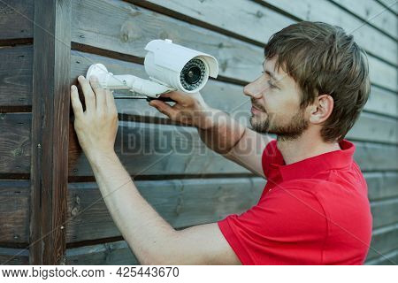 Caucasian Technician Installing Ip Wireless Cctv Camera By Screwed For Home Security System