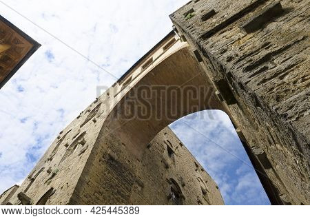 Bottom View Of A Tall Ancient Arch And Blue Sky With Clouds