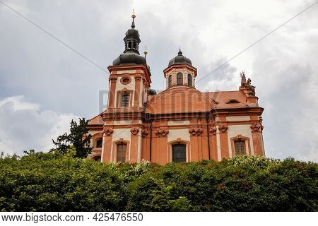 Valec, Western Bohemia, Czech Republic, 19 June 2021:  Baroque Red And Yellow Church Of The Holy Tri