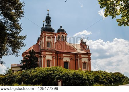 Valec, Western Bohemia, Czech Republic, 19 June 2021:  Baroque Red And Yellow Church Of The Holy Tri