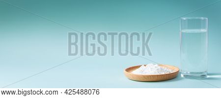 Collagen Powder And Glass Of Pure Water On Blue Background. Natural Bio Supplement For Skin, Bone An