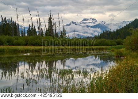 Vermilion Lakes Morning Mist Alberta. Vermilion Lakes Reflection Of Clouds And Snowcapped Mountains.