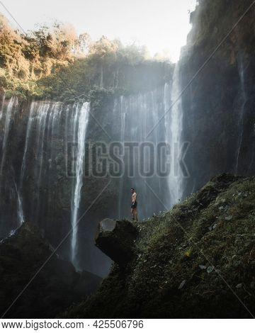 Man standing by Tumpak Sewu Waterfalls, Indonesia
