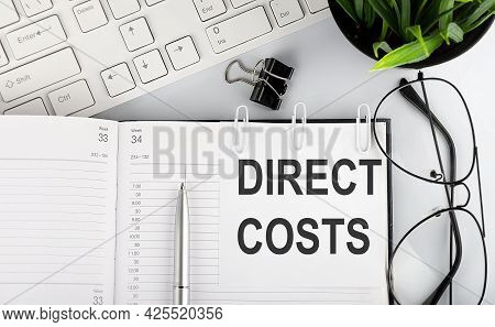 Text Direct Costs Stickers On Notebook With Keyboard And Glasses.