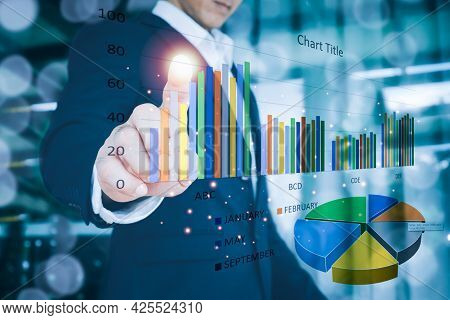 A Man Wearing A Suit His  Right Hand Point On A Stock Chart. Blurred Background .