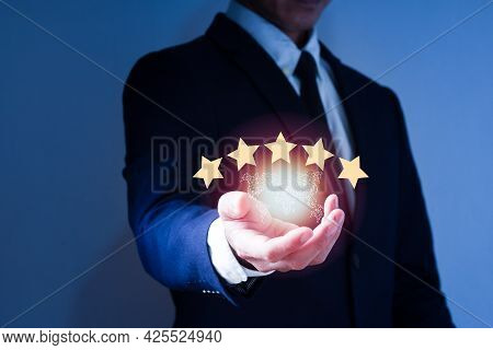 The Right Hand Of The Man Wearing A Suit Has A 5-star Sign And World Map,  The Concept Is Satisfacti