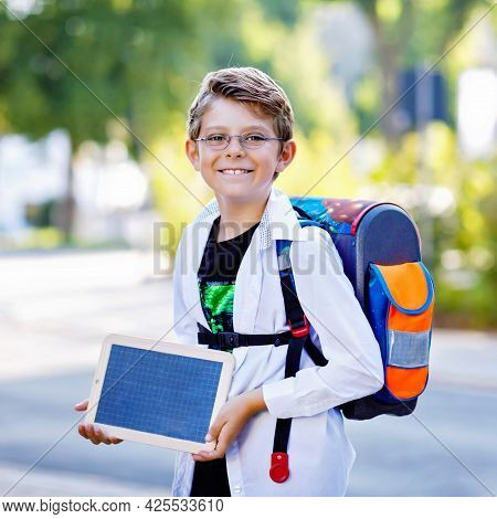 Happy Little Kid Boy With Glasses And Backpack Or Satchel. Schoolkid On The Way To School. Healthy A