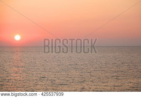 Big Sun And Warm Colors Over The Water Of Ocean