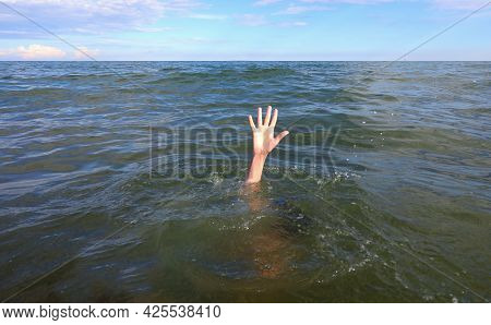 Hand Of The Person In Distress Who Is About To Drown In The Middle Of The Sea