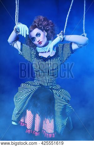 The actress plays a doll on strings at a performance in a puppet theater. A portrait in retro style.