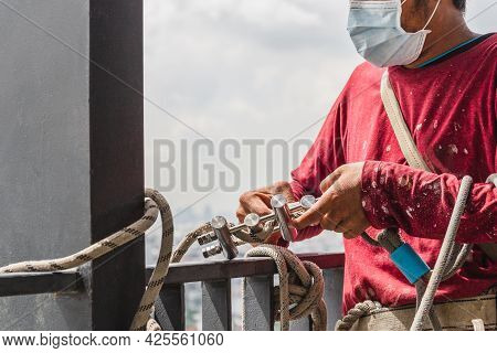 Construction Workers Holding Steel Hooks Connecting With Rope For Self Absorber Safety Device Equipm