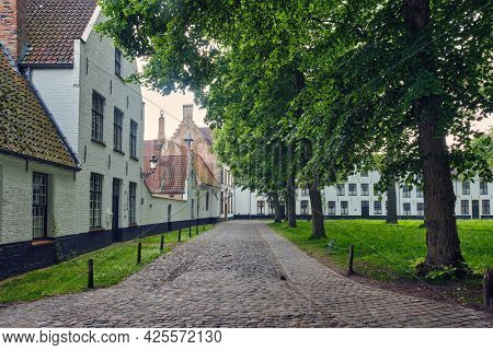 Old houses and garden of Begijnhof Beguinage in Bruges town. Brugge, Belgium
