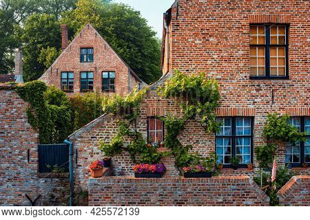 Old housesof Begijnhof Beguinage with flowers in Bruges town. Brugge, Belgium