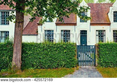 Old houses and garden of Begijnhof Beguinage in Bruges town. Brugge, Belgium