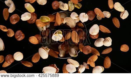 Rotating Various Nuts on Black Background. Top Shot.