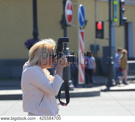 A Blonde Woman Photographer On The Street At Work, Dvortsovy Proezd, St. Petersburg, Russia, July 20