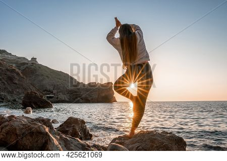 Young Woman With Long Hair In Sportswear And Boho Style Braclets Practicing Outdoors On Yoga Mat By 