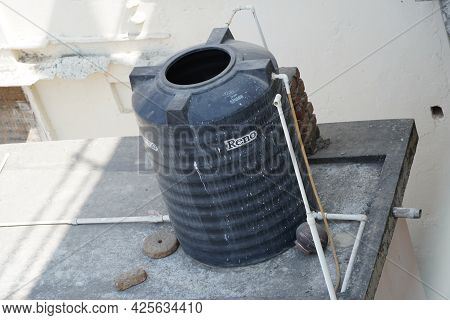 Black Water Tanks Of Industrial Building On Roof Top Or Deck Of An Old Residential Building In A Rur