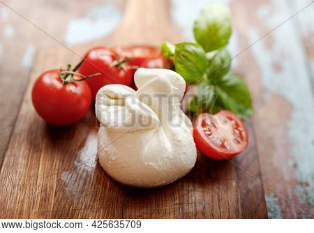 Burrata Cheese On Wooden Vintage Board. Soft Cheese With Tomatoes And Basil Leaves On Wooden Table. 