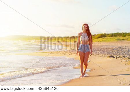 Lonely Young Woman Walking On The Beachsunset Day.beach Woman In Fashion Beachwear Relaxing Walking 