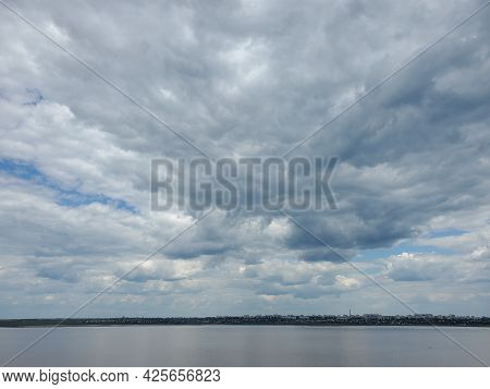High Overcast Sky With White Fluffy Cumulus Clouds Floating In Wind. Tranquil Cloudscape Over Calm W