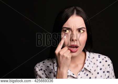 Woman Checking Her Health Condition On Black Background, Space For Text. Yellow Eyes As Symptom Of P