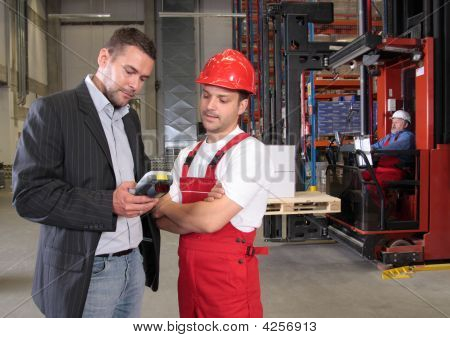 เจ้านายพูดกับผู้ปฏิบัติงานในเครื่องแบบในโรงงาน