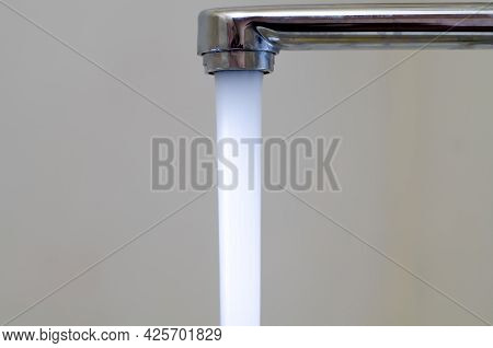 Water With Bubbles Flows Down From The Water Tap