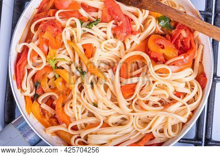 Vegetarian Linguini Pasta With Tomatoes And Bell Peppers In A Frying Pan, Top View, Close-up