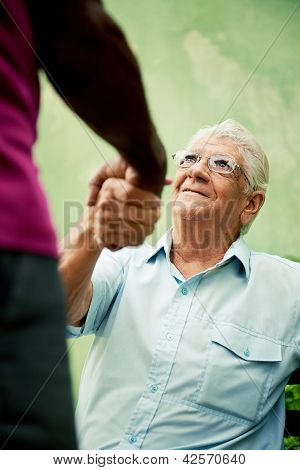 Vecchia riunione di uomini neri e caucasici e agitando le mani nel parco