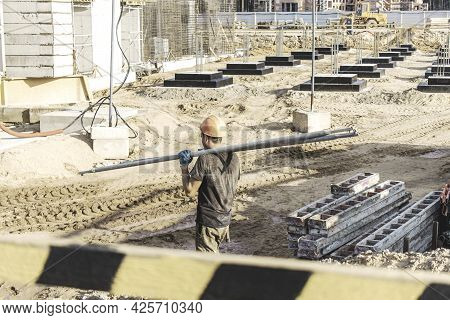 A Worker Transfers Elements For The Installation Of The Formwork At The Construction Site. Monolithi