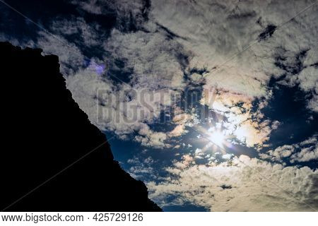 Dramatic View Of Silhouette Mountainside Against Sundog Sky