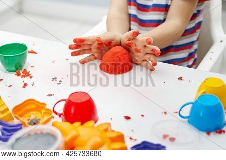 A Childs Hands Play With Bright Kinetic Sand On A White Table. An Educational Game Of Kinetic Sand W