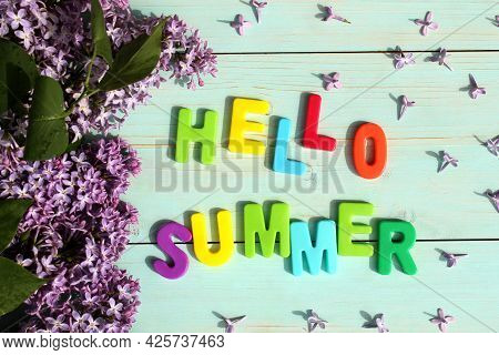On A Wooden Background There Is An Inscription In Multicolored Letters Hello Summer Surrounded By Li