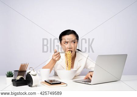 Asian Woman Working Hard Overtime Eating Instant Noodles At Office.