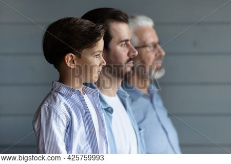 Serious Thoughtful Boy Kid Standing In Row With Young Fath