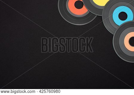 Multi Colored 7 Inch Single Vinyl Records On A Black Background With Empty Space For Text. Top Down 