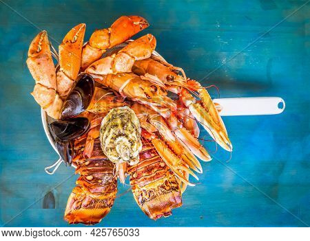Fresh Seafood Catch Of Lobsters, Crabs, And Langostines On Blue Background, Toned