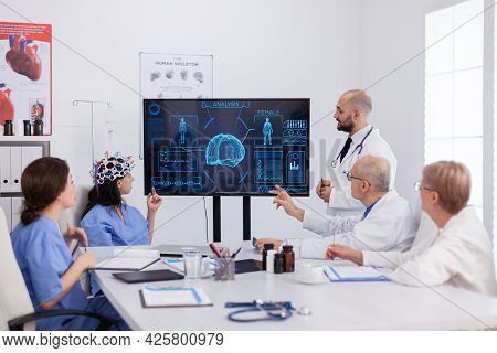 Neurologist Man Doctor Checking Brain Expertise Using Headset With Sensors On Woman Asisstant In Hos
