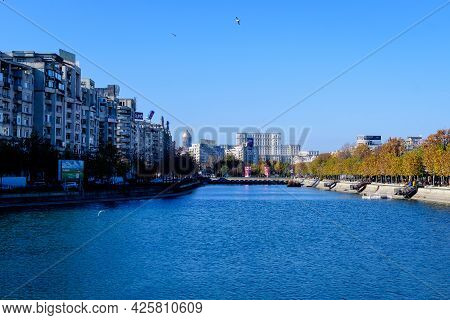 Bucharest, Romania, 22 November 2020: Landscape With Dambovita River, Old Buildings And Yellow, Oran