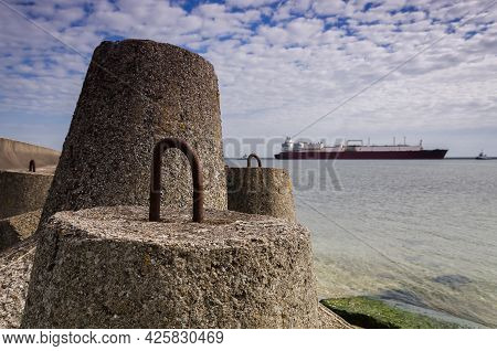 Dolos And Lng Tanker - Ship Against Background Of Concrete Protection Of The Seaport And Sea Coast