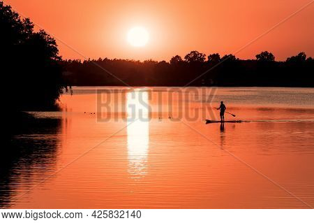 Stunning Silhouette Of A Man Floating On The Surfboard | Paddleboard At Amazing Orange Sunset Over T