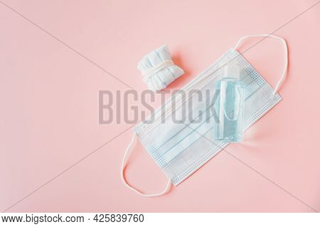 Bottle Of Alcohol Gel On Blue Disposable Face Mask And Used Mask, Necessary For New Normal Lifestyle