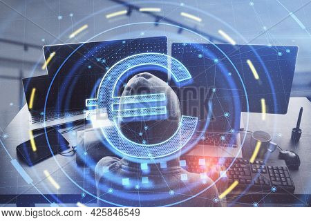 Top View Of Hacker Using Computer With Glowing Euro Sign In Blurry Office Interior. Online Banking A