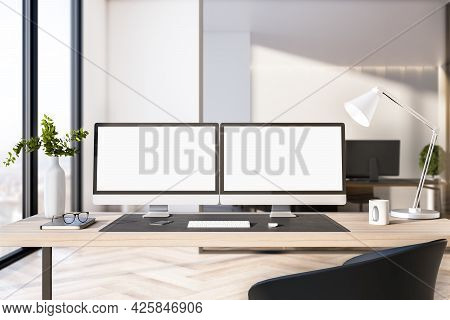 Two Empty White Computer Screens On Office Desktop In Interior With Daytime City View. Corporate Tem