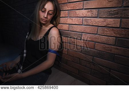Overdosed Drug Addicted Woman Near Brick Wall. Space For Text