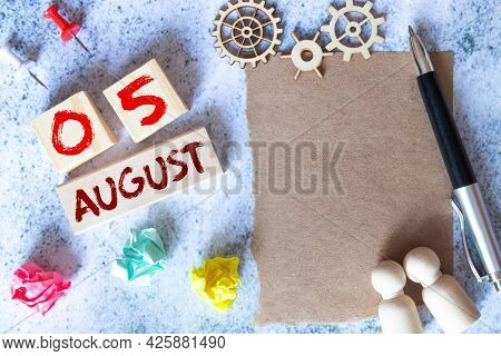 August 5. Date Of August Month. Number Cube With A Flower And Notebook On Diamond Wood Table For The